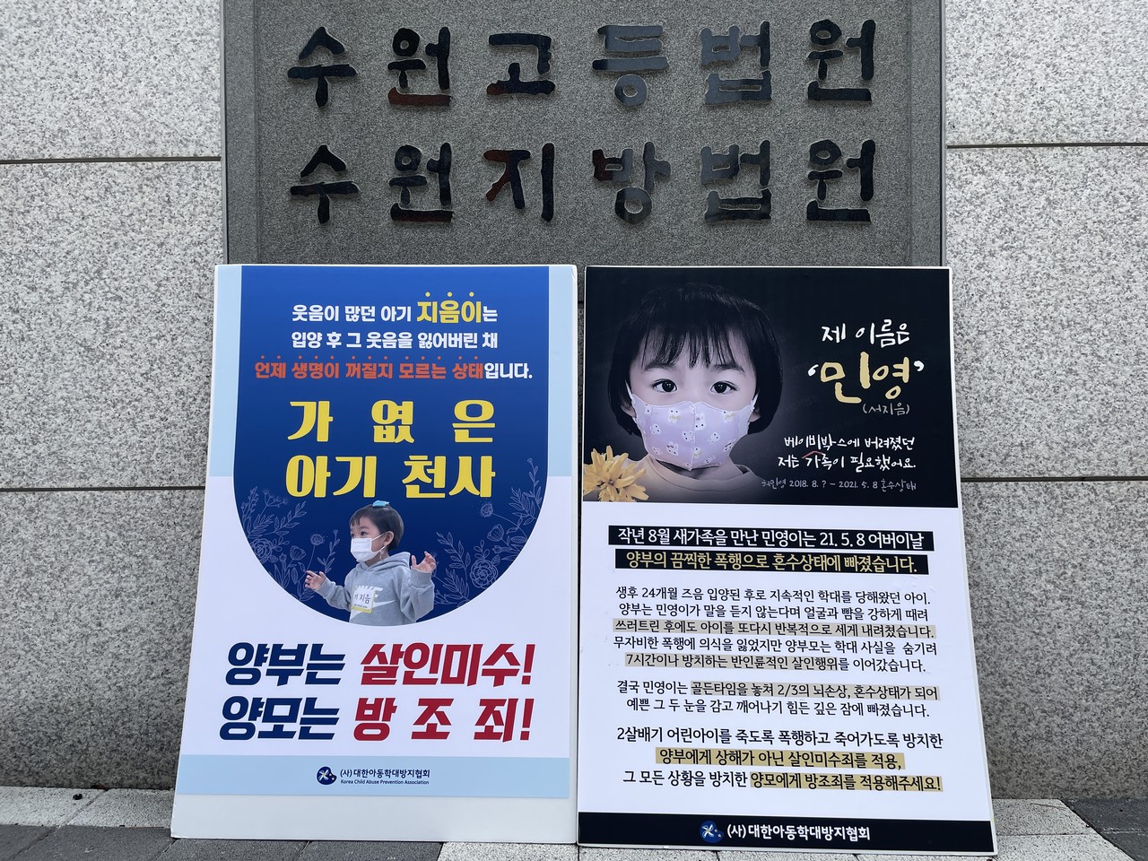 화성 2세 입양아 학대 뇌사 사건의 첫 재판이 열린 수원지방법원 앞에 대한아동학대방지협회 회원들이 준비한 피켓이 놓여 있다.